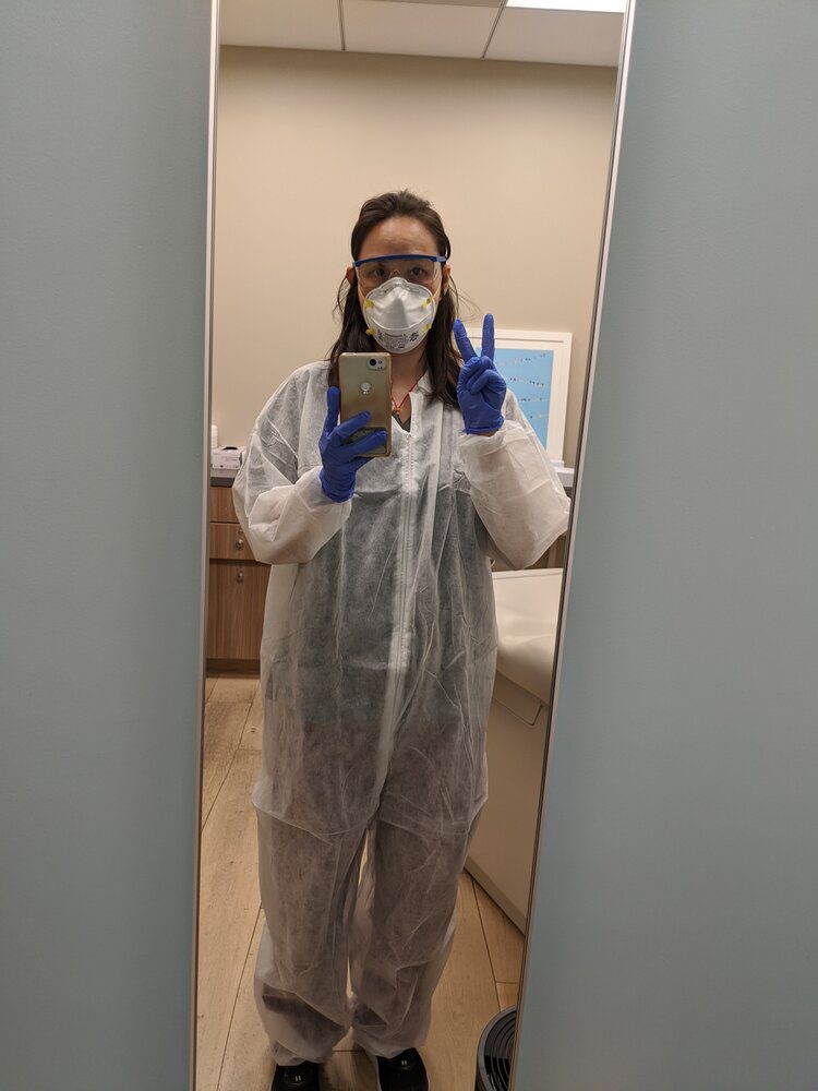 a woman in PPE suit clicking a mirror selfie a woman in PPE suit clicking a mirror selfie