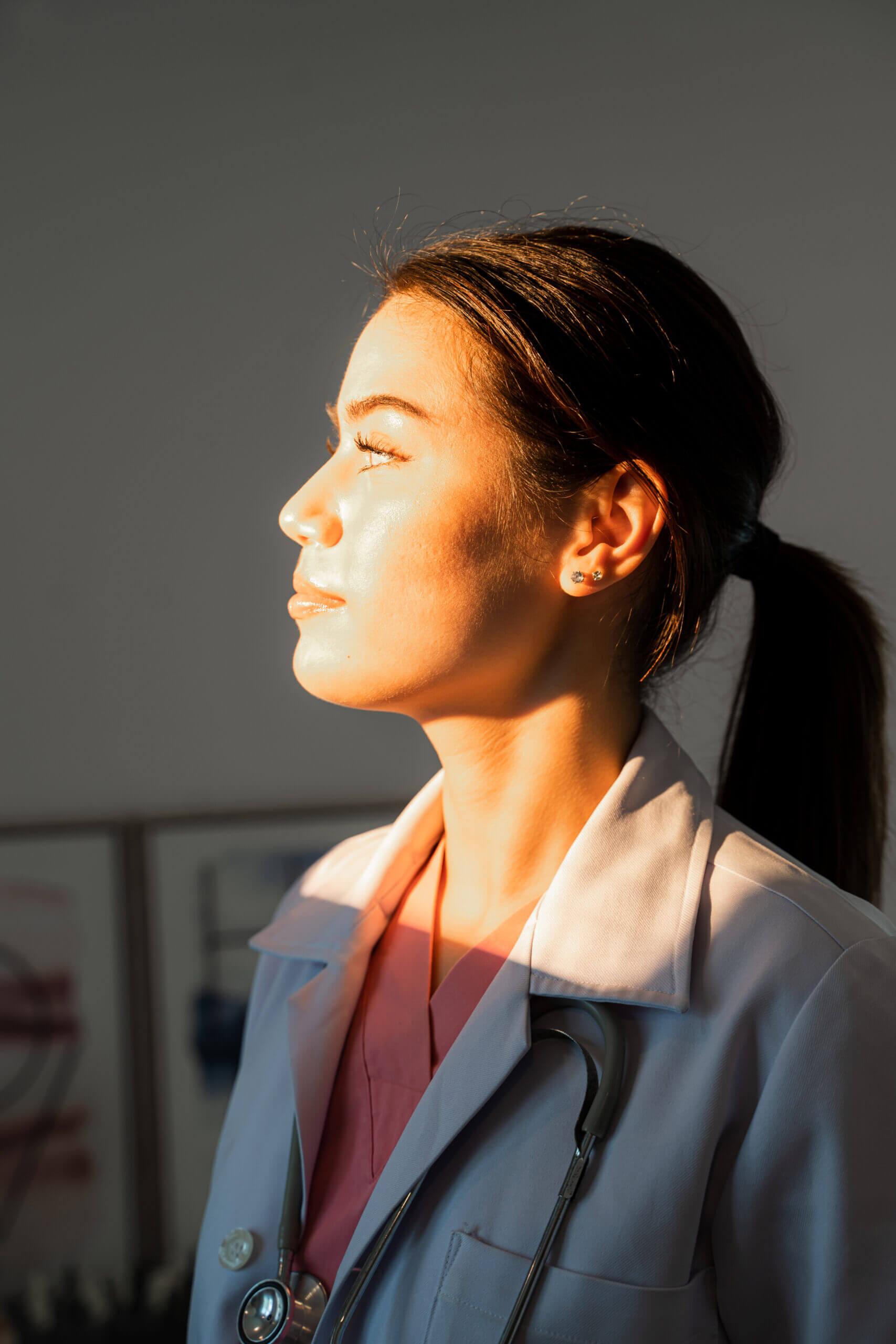 Doctor in sunlight with stethoscope, profile view.