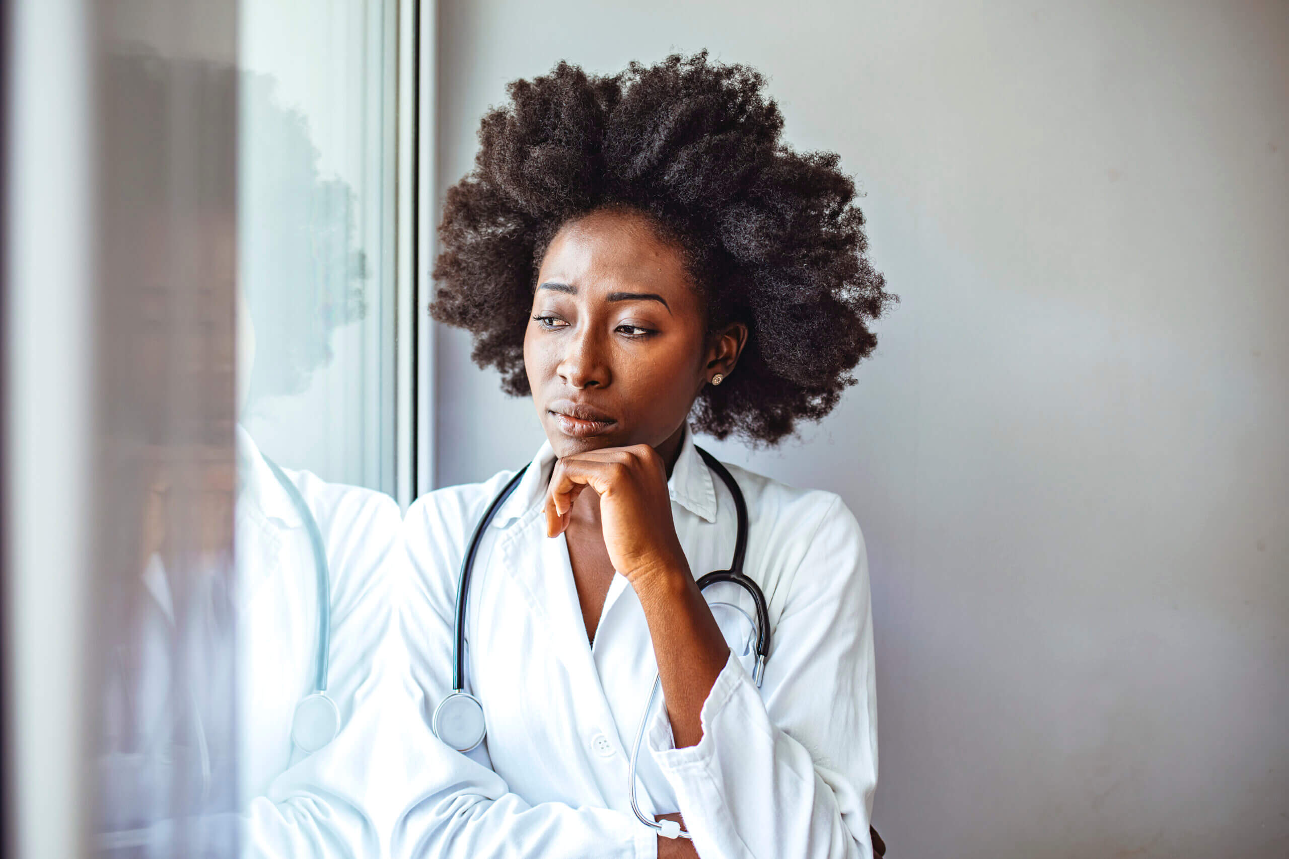 Doctor gazing thoughtfully out a window. Doctor gazing thoughtfully out a window.