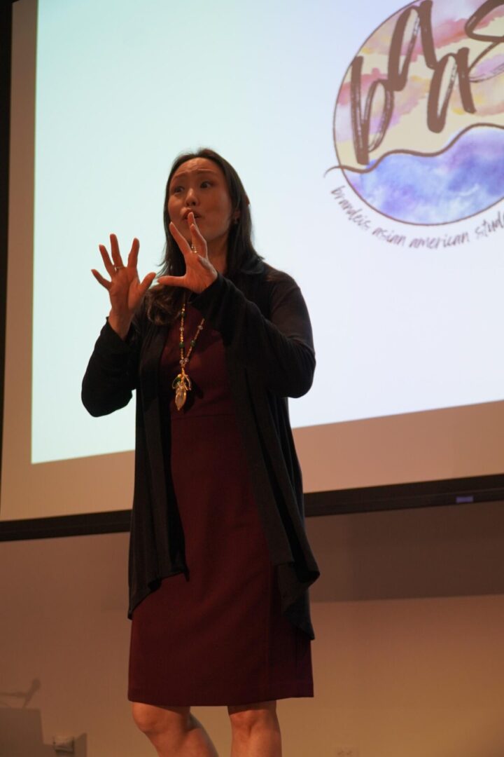 Woman speaking on stage with hand gestures